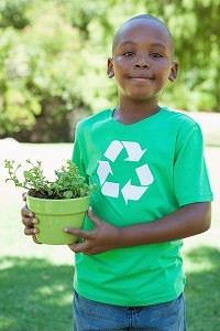 Little boy in recycling tshirt holding potted plant