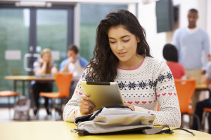 Female Teenage Student In Classroom With Digital Tablet