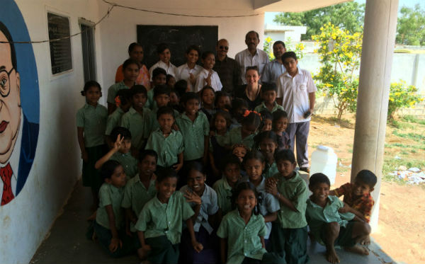 Fotografía de Claire con los alumnos del PAI y los alumnos más pequeños del colegio público local