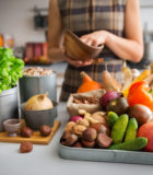 Sensibiliser à la maladie de Crohn 43733138 - a tray full of autumn fruits, nuts, and vegetables sits on a kitchen counter. next to the tray, a wooden cutting board featuring a fresh basil plant and onion promise a delicious meal ahead.