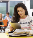 Female Teenage Student In Classroom With Digital Tablet