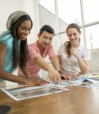 Préparons les élèves à un avenir brillant A multi-ethnic group of business professionals are looking over pictures in the boardroom.