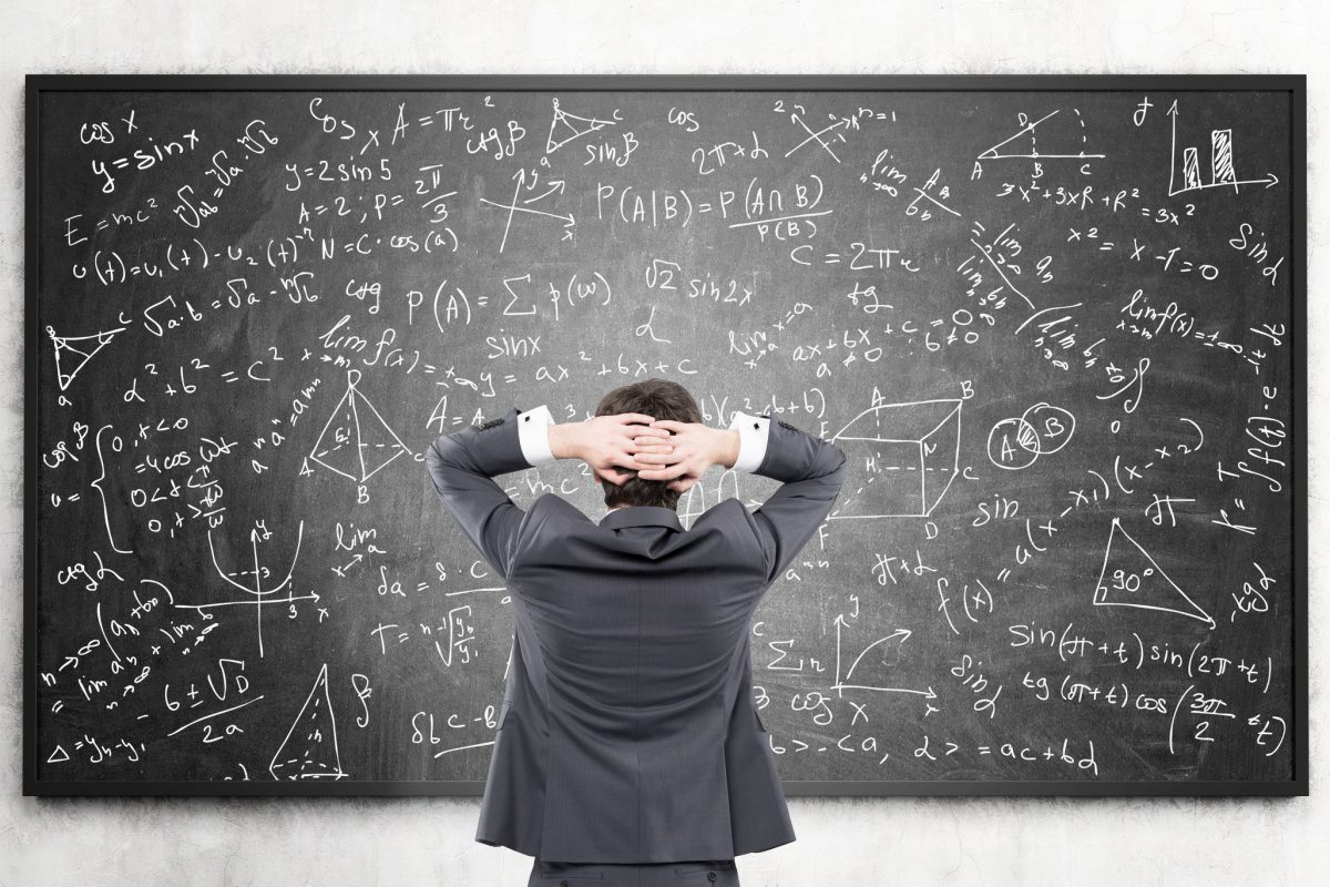 Businessman looking at formulas at blackboard