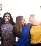 Group of school friends outdoors arms around one another togetherness and community concept