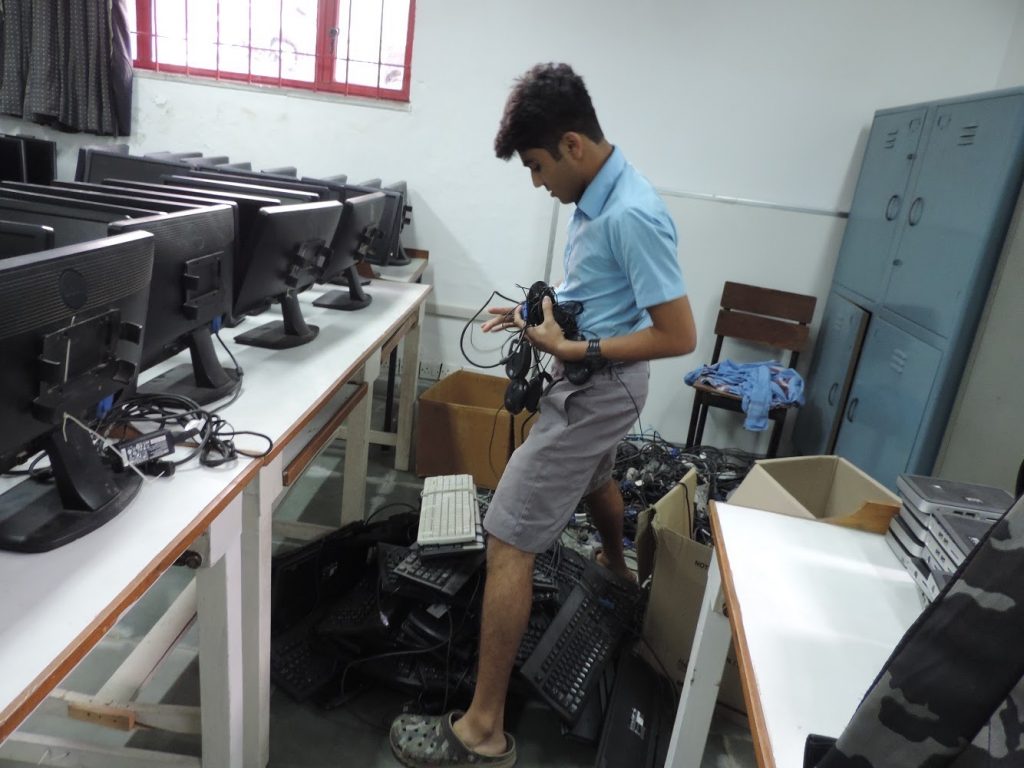 Rishit Jan sorting through the electronic waste collected by the REUSE team.