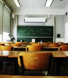 A large, empty classroom, lit by morning light.