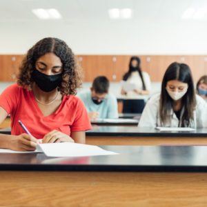 High school students and teenagers go back to school in the classroom at their high school. They are required to wear face masks and practice social distancing during the COVID-19 pandemic. They value their education and are excited to be in school. Image taken in Utah, USA.